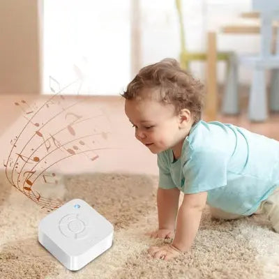 Bébé jouant sur le tapis avec une machine à bruit blanc 9 sons apaisant