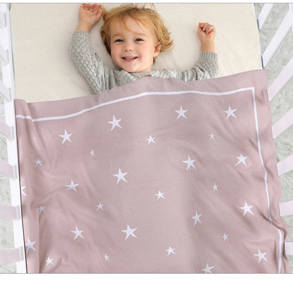 Bébé endormi sous une couverture étoile pour bébé en coton rose
