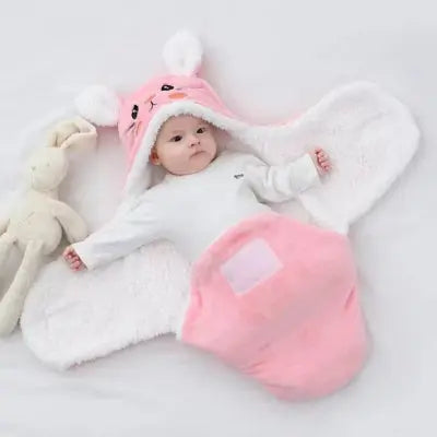 Bébé installé dans un nid d’ange rose