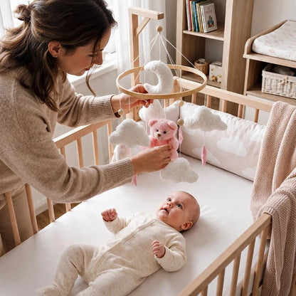 Bébé observant son mobile ourson lune et étoiles