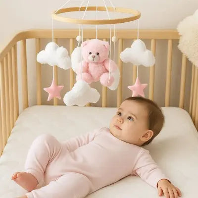 Bébé observant un  mobile pour lit bebe  nuages cloche de lit artisanale

