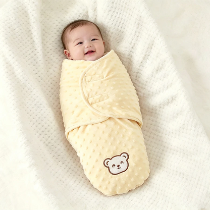 Bébé souriant emmailloté dans un nid d'ange bebe jaune 