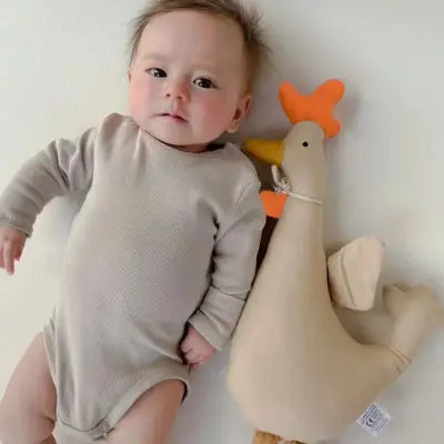 Bebe allonge avec un doudou forme coq