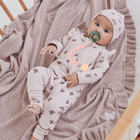 Bébé avec une attache-tétine verte douce en coton