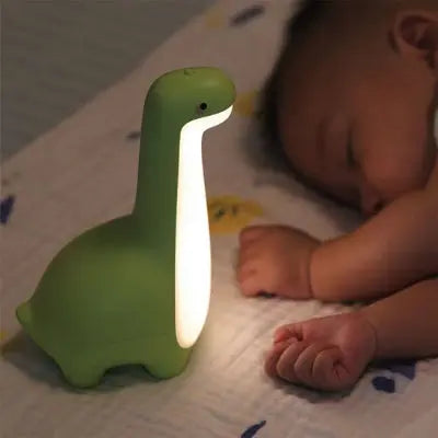 Bébé endormi avec veilleuse bébé dinosaure vert