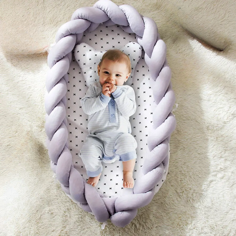 Bébé endormi dans tour de lit tressé