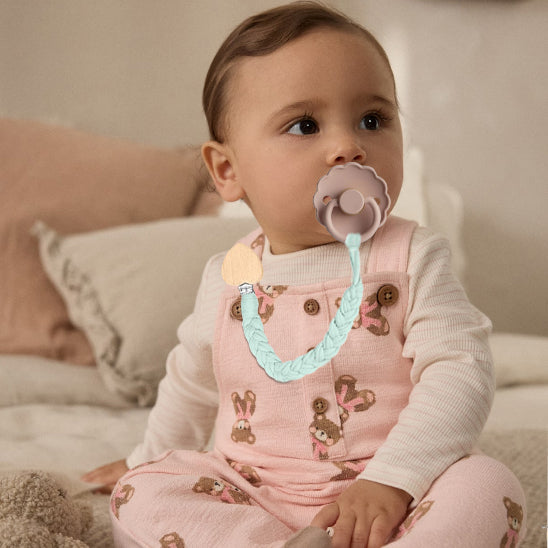 Bébé portant une attache-tétine verte en coton