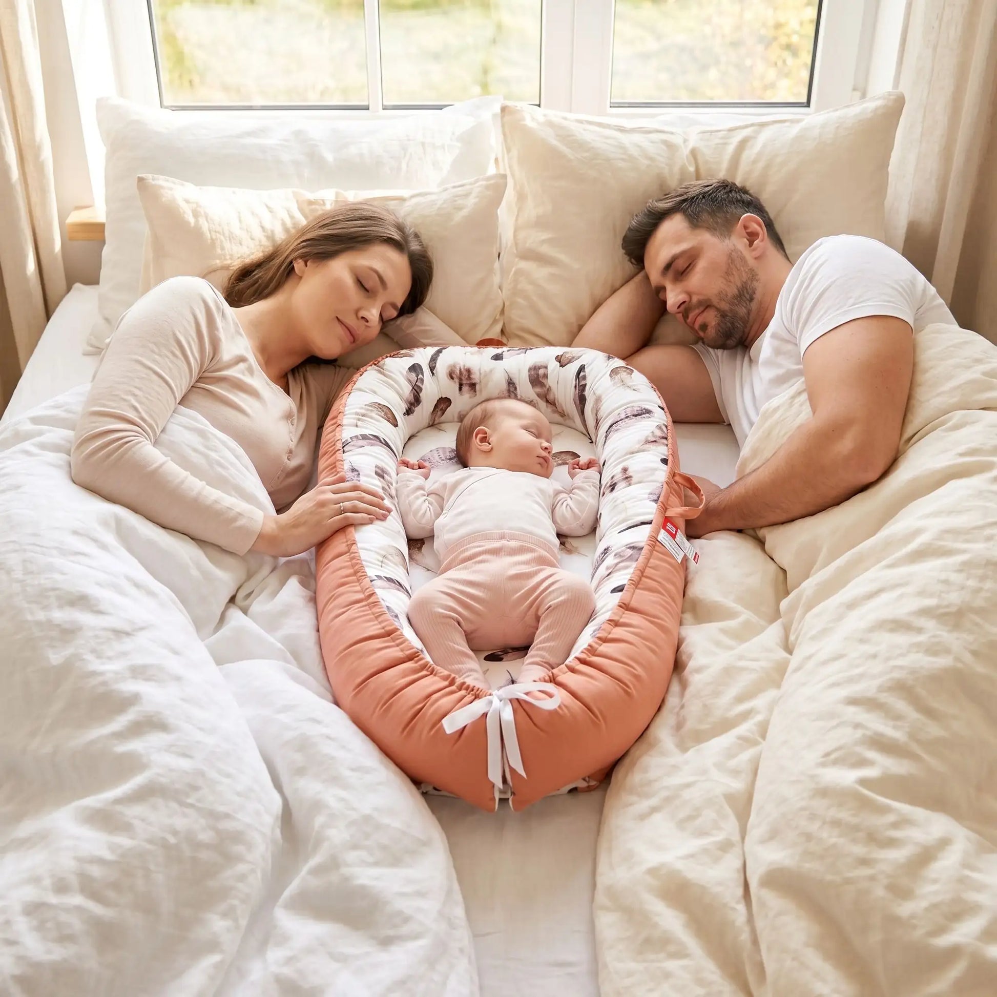 Cale-bébé ergonomique et nomade dans le lit du parent