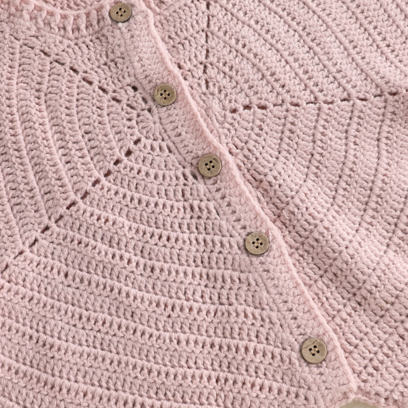 Combinaison bébé naissance rose, gros plan sur la maille tricotée et les boutons