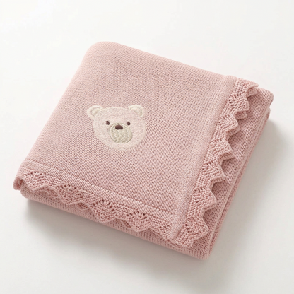 Couverture bébé au tricot rose poudré à ourson brodé