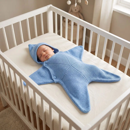 Couverture bébé étoile tricot bleu portée par bébé dans son lit