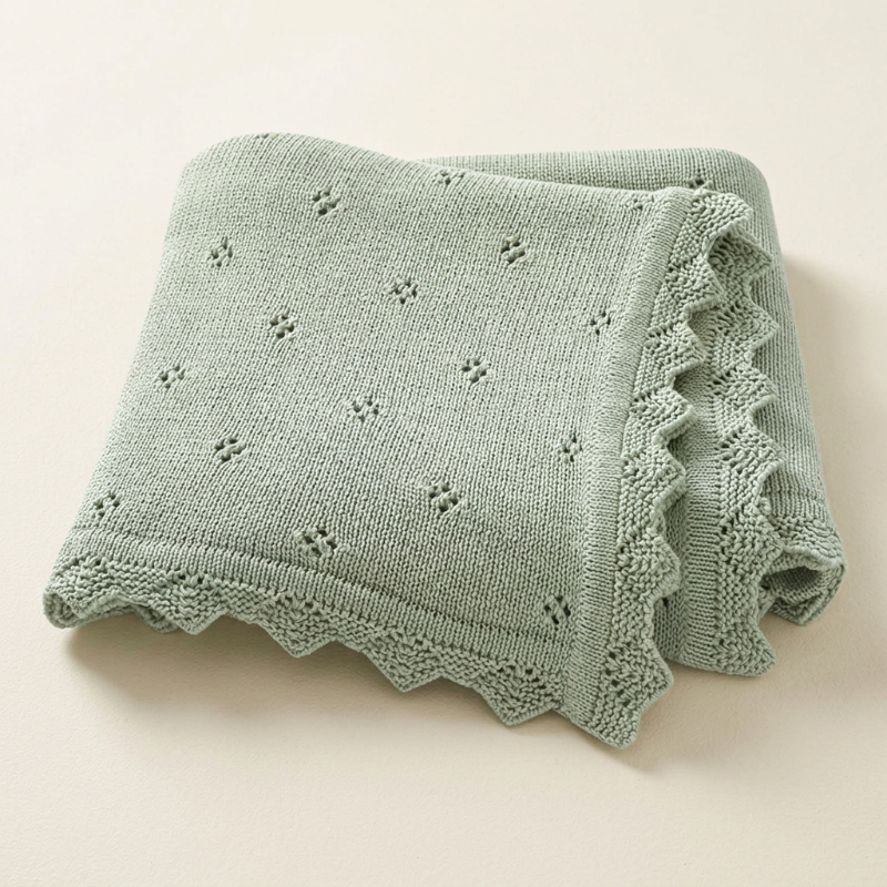 Couverture en tricot bébé vert sauge, détail de la bordure zigzag