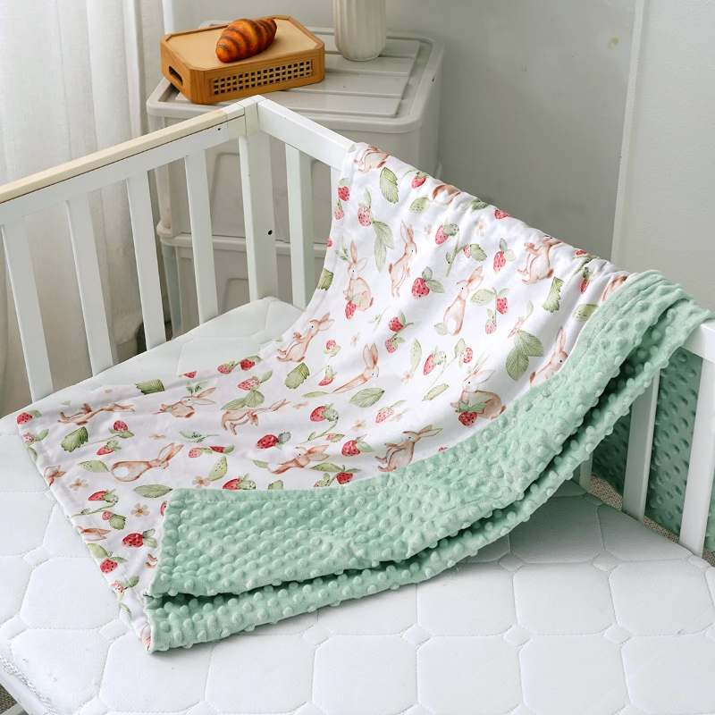 Couverture hiver bébé verte posée sur un lit bébé
