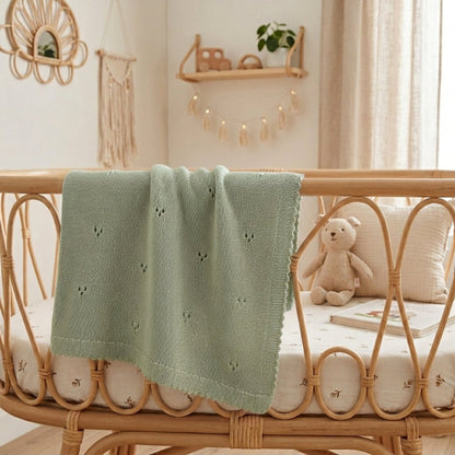 Couverture pour bébé au tricot verte, maille ajourée et bord festonné