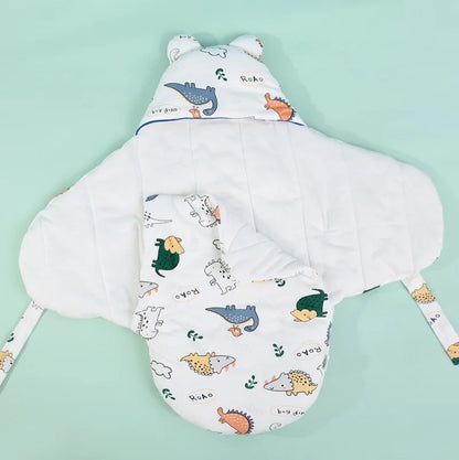 Couverture pour emmailloter bébé dinosaures ouverte avec capuche à oreilles