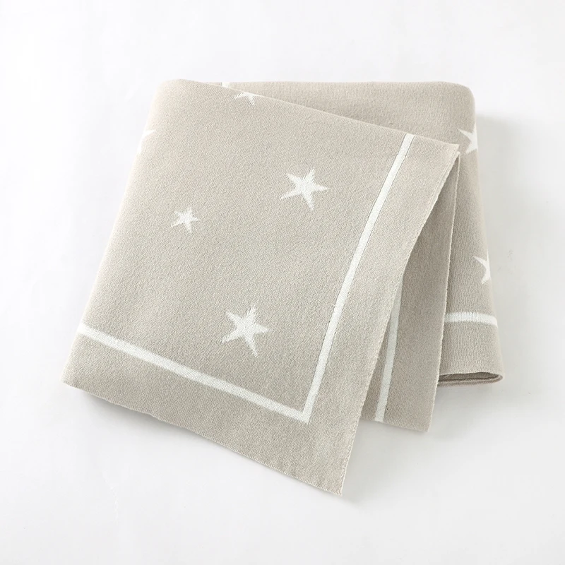 Couverture étoile pour bébé en coton beige clair pliée