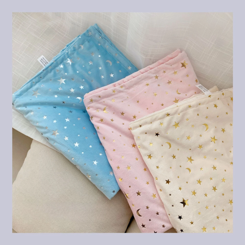 Couverture étoile pour bébé présentée à plat en trois coloris