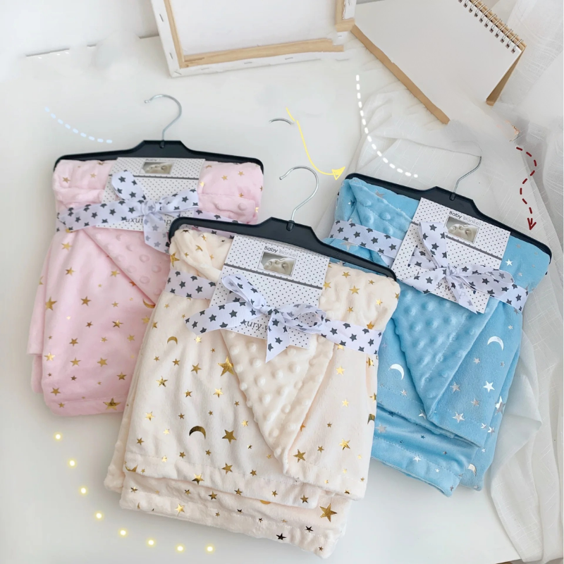 Couverture étoile pour bébé présentée pliée avec des rubans