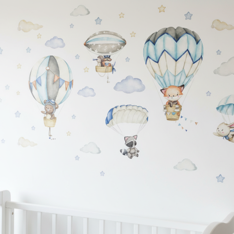 Décoration murale avec stickers muraux enfant montgolfières bleu pastel et petits animaux pour lit de bébé.