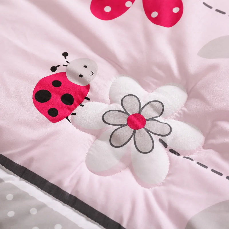 Détail du tour de lit bébé fille avec motif coccinelle et fleurs brodées
