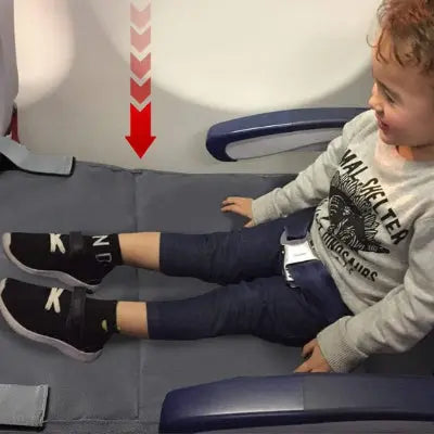 Enfant dans l'avion posant ses pieds sur lit de voyage bébé cris 