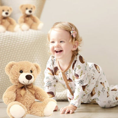 Fillette jouant avec un ours en peluche beige