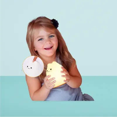 Fillette jouant avec une veilleuse bébé chat 