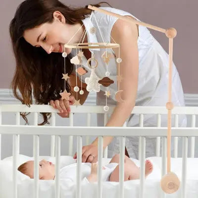 Maman observant son bébé dans un lit avec mobile bébé avec nuages Lune étoiles fait main