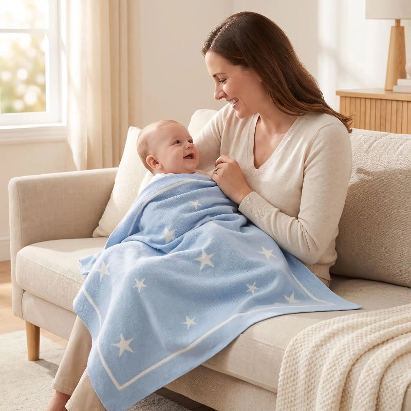 Maman sur le canapé, bébé dans une couverture coton bébé bleu ciel