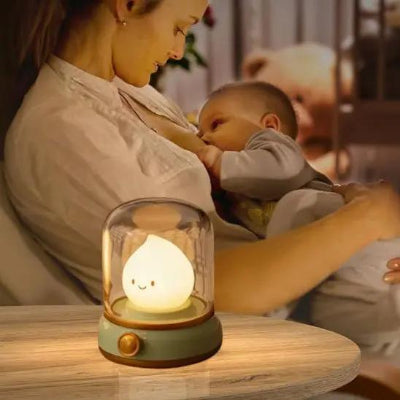 Moment d’allaitement nocturne avec une veilleuse bébé sécurisée en forme de flamme  