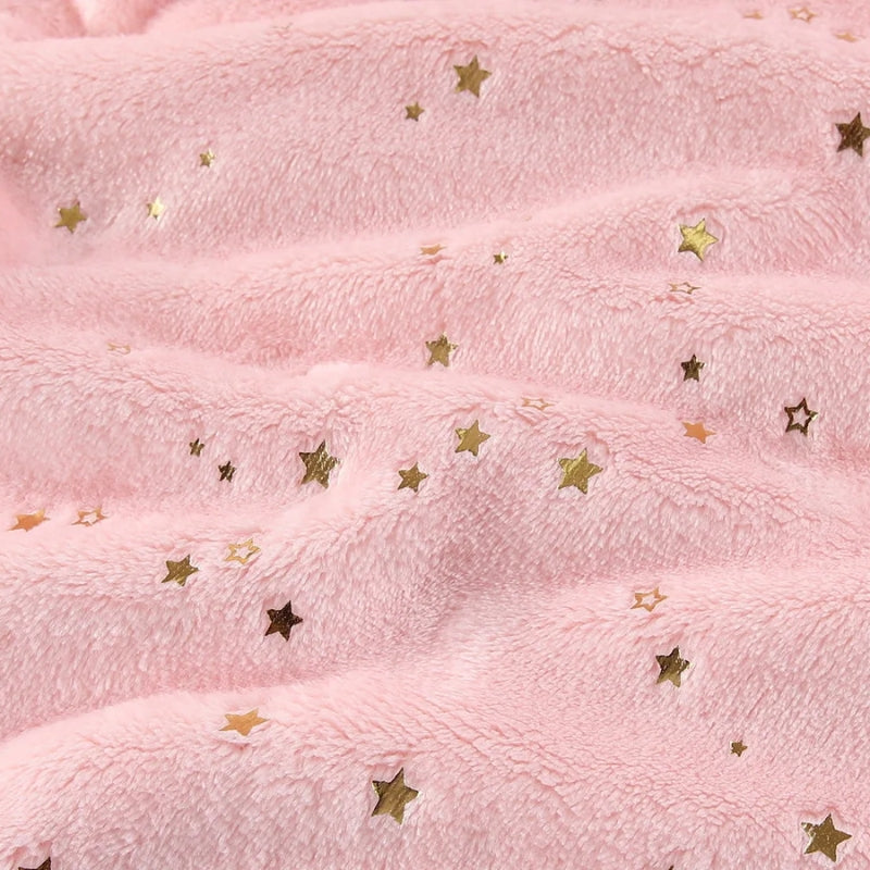 Motif étoiles pailletées sur le velours d'une couverture étoile pour bébé.