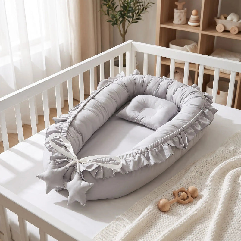 Nid bébé gris à volants dans un lit bébé