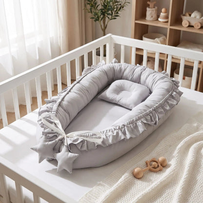 Nid bébé gris à volants dans un lit bébé