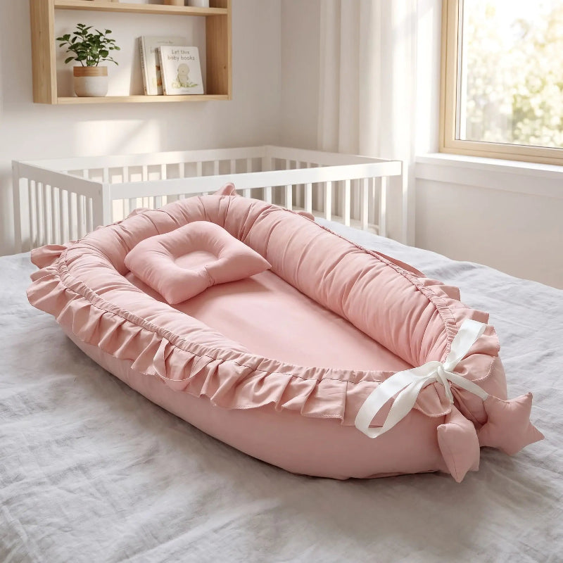 Nid bébé vieux rose à volants avec son coussin assorti
