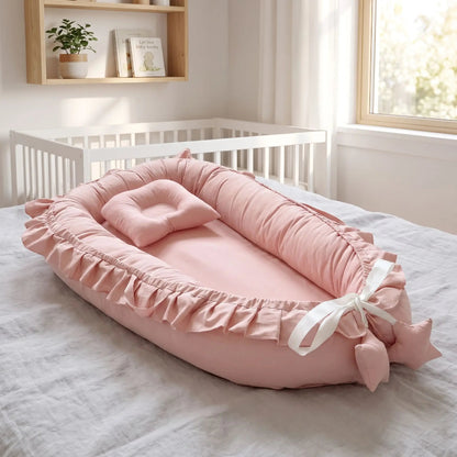Nid bébé vieux rose à volants avec son coussin assorti