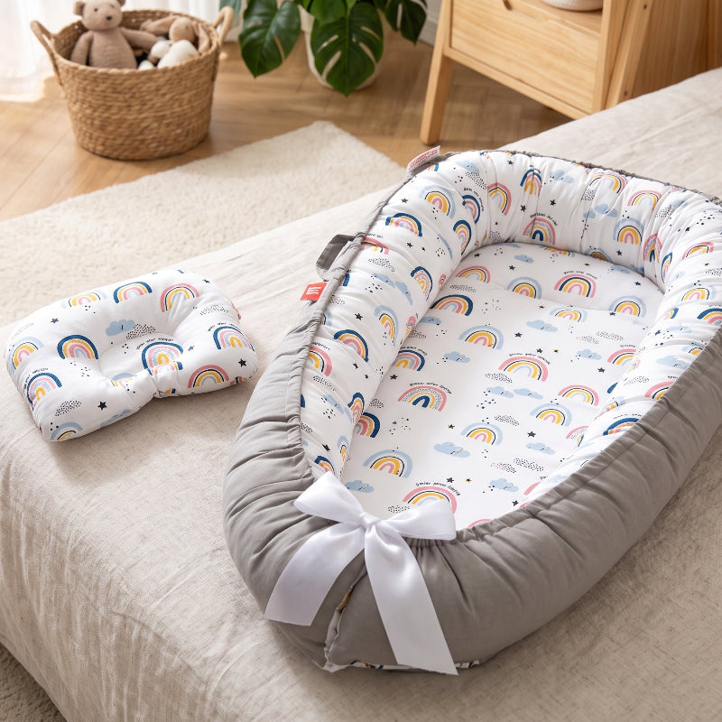Nid de bébé arc-en-ciel et son petit coussin assorti