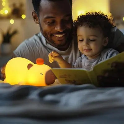 Père et fils lisant une histoire avec une veilleuse bébé 