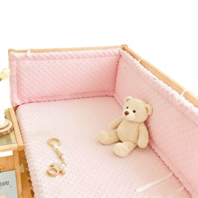 Protection tour de lit bébé rembourré rose pastel installé en tête de lit