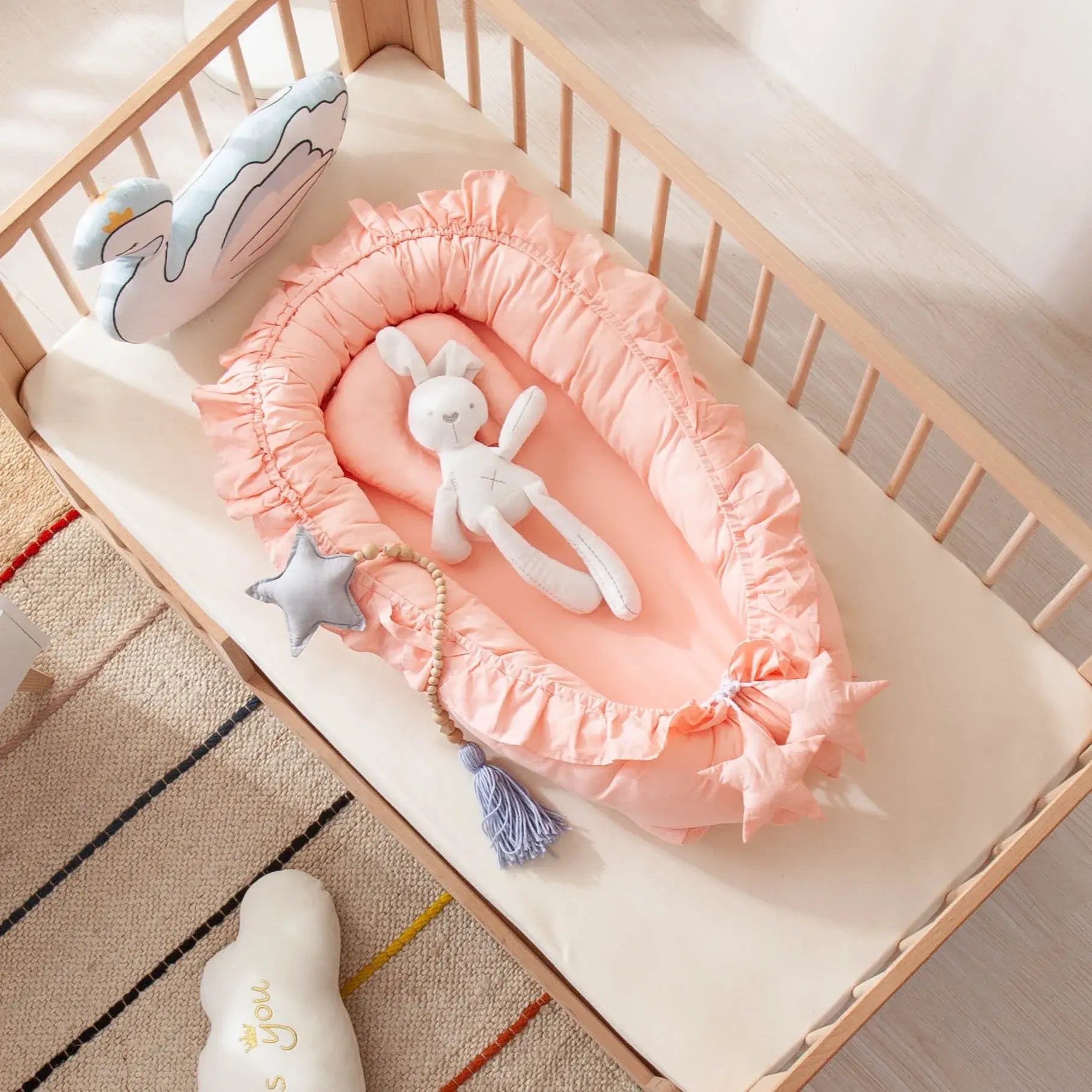 Réducteur de lit bébé Nid Portable – rose dans lit à barreaux