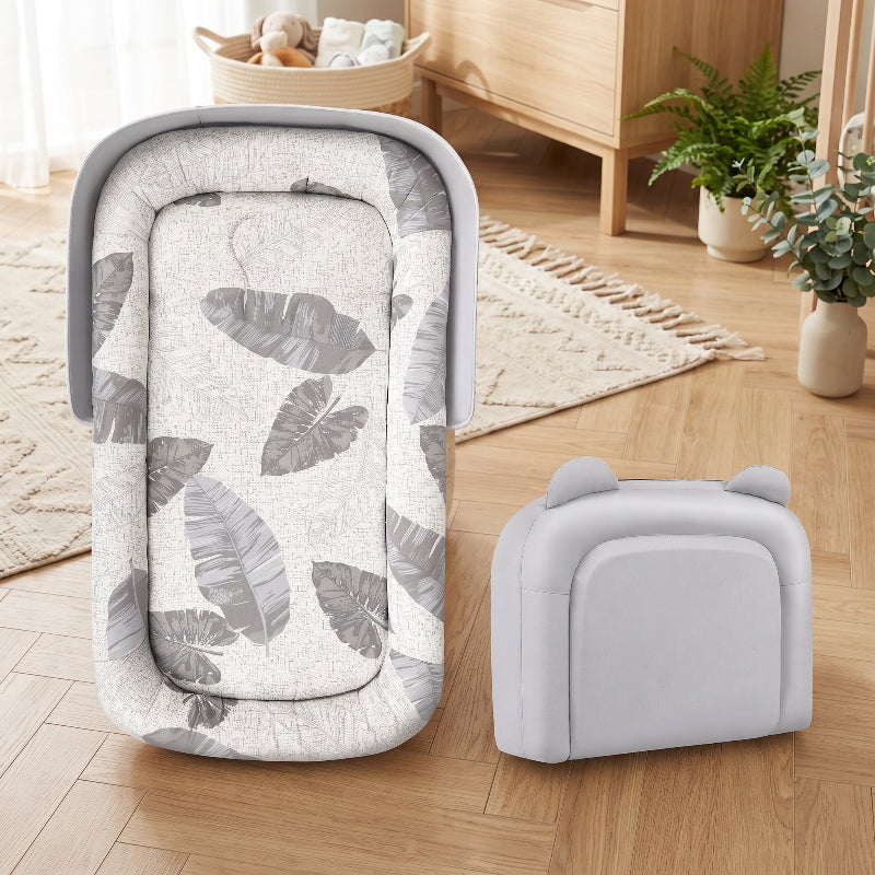Réducteur de lit bébé pliable ouvert à côté de son sac de transport