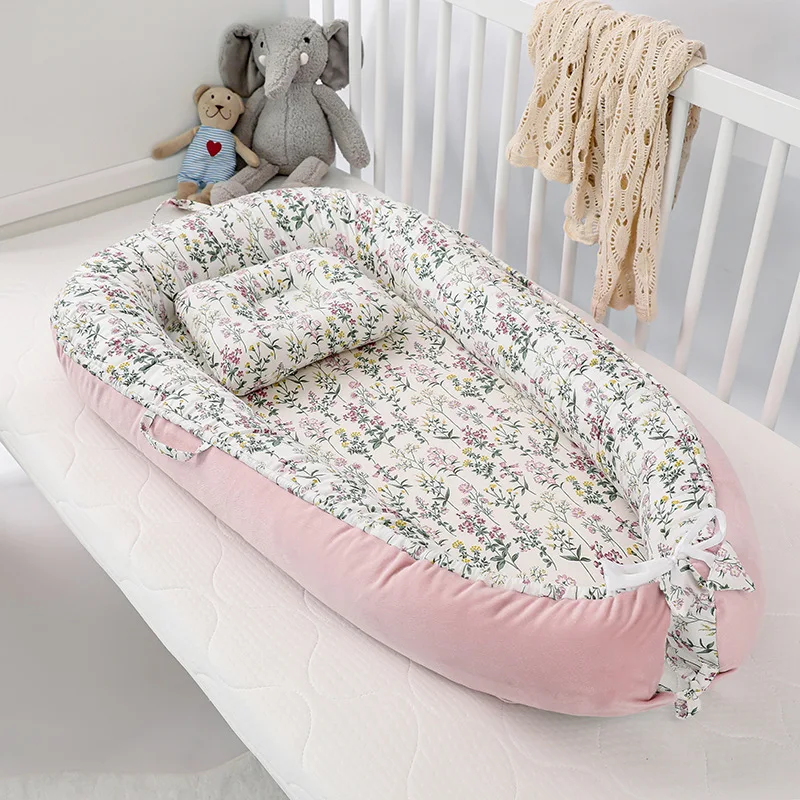 Réducteur de lit bébé rose motif plantes à l'intérieur
