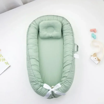 Réducteur de lit bébé anti-pression vert sauge.