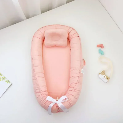 Réducteur de lit bébé rose bionique.