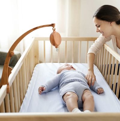 Support pour mobile bebe en bois installe au dessus du lit