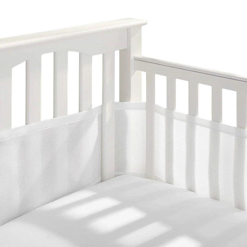 Tour de lit respirant en maille installée dans un lit bébé