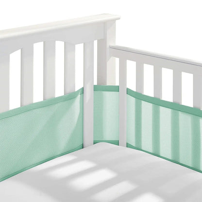 Tour de lit respirant vert installé sur un lit bébé