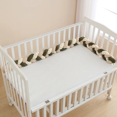 Tresse de lit bébé verte et écrue installée dans un lit pour sécuriser l’espace de sommeil