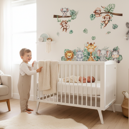 Un garçon à côté d'un berceau de style scandinave décoré de stickers muraux animaux pour chambre enfant.