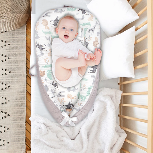 bebe allonge dans un reducteur de lit respirant en coton gris