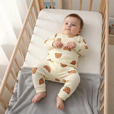 Bébé allongé en pyjama bébé garçon beige imprimé.